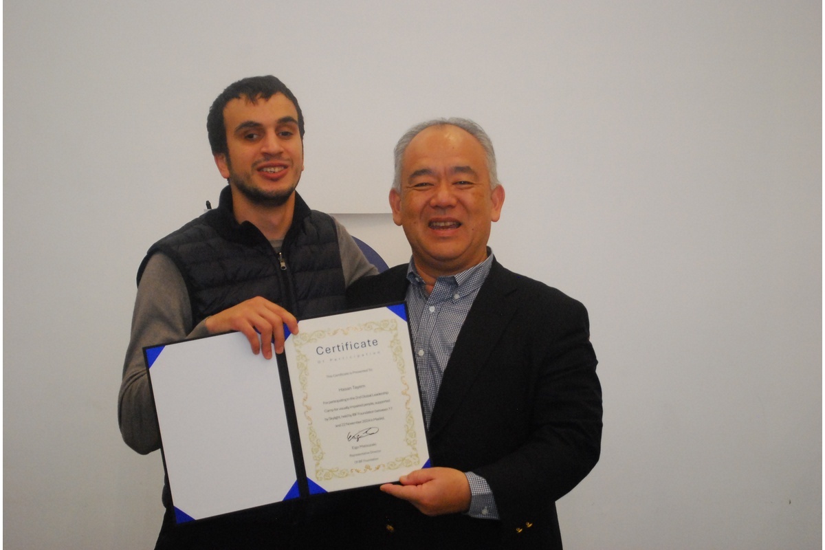 Hasan is receiving a certificate at a conference